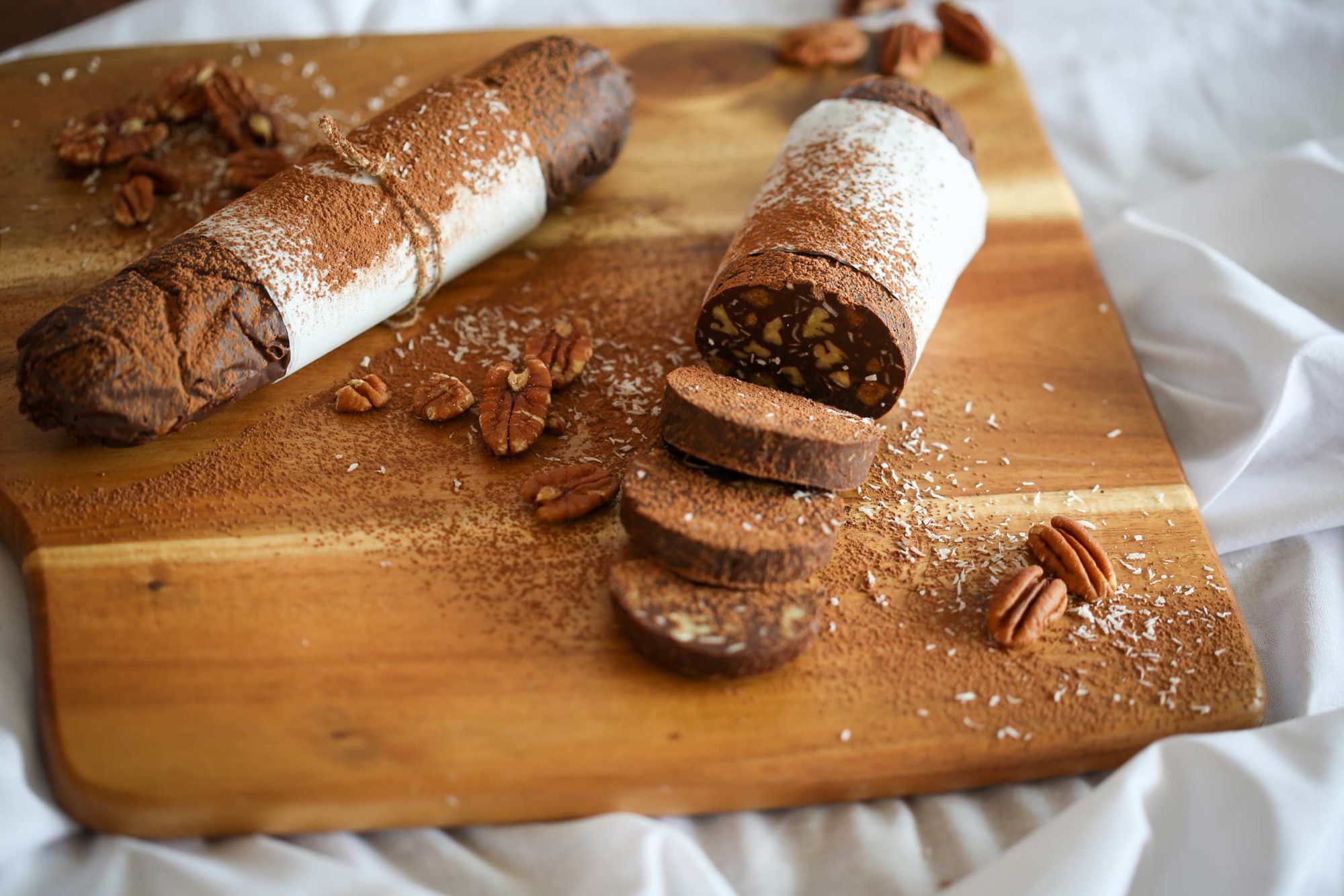 Chocolate salami rolls made with smooth dark chocolate and filled with nuts, cookis and coconut