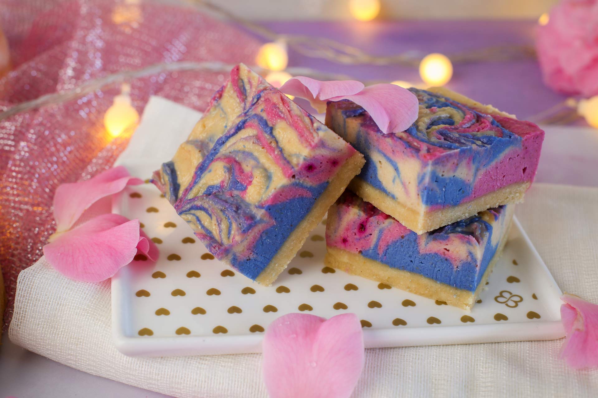A pretty plate of unicorn slices covered with rose petals and surrounded with fairy lights