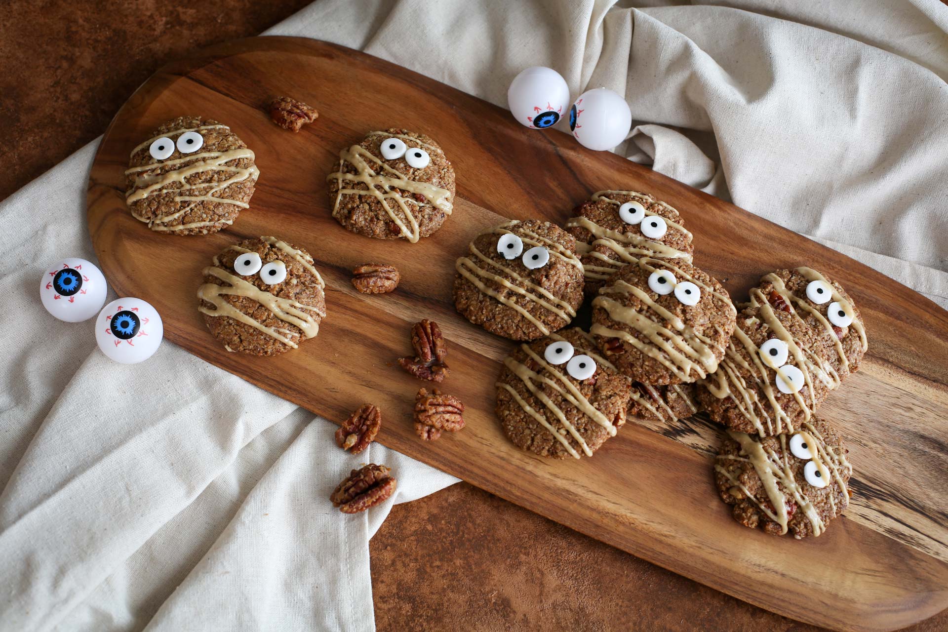A platter of halloween candied pecan cookies dressed up as mummies